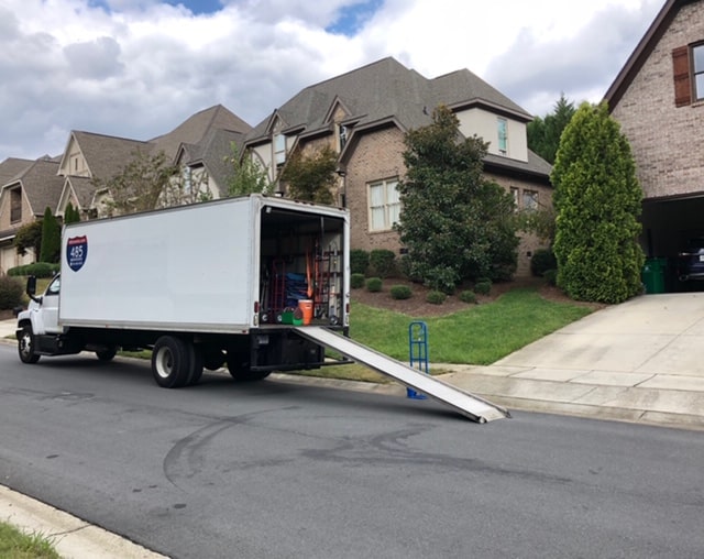 Professional moving truck parked in front of a customer's house, ready for a seamless relocation. 485 Movers Charlotte offers expert moving services, making the process stress-free and efficient. Trust our experienced movers to handle your belongings with care during the move. Get a free quote today!